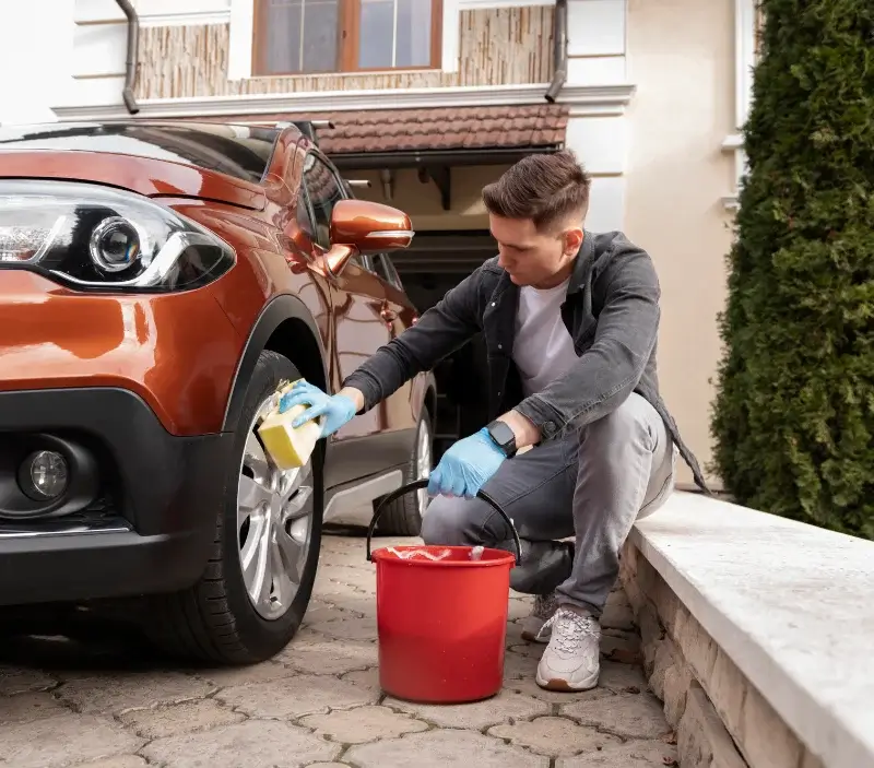 Lavage auto à domicile Les Trois-Châteaux : professionnel intervenant sur un véhicule